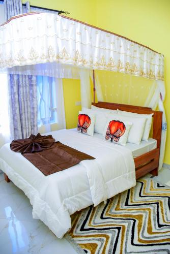 a bedroom with a large bed with a canopy at JOSEPHINA LODGE Dodoma in Dodoma