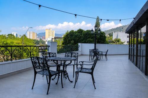 a patio with tables and chairs on a balcony at Alko Select in Cali