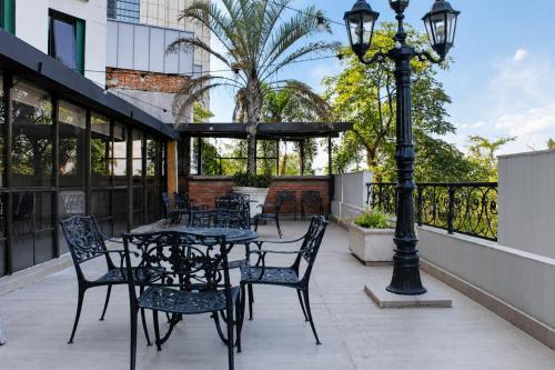 a patio with tables and chairs and a street light at Alko Select in Cali