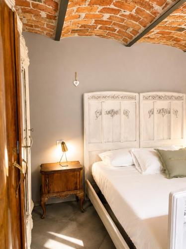 a bedroom with a bed and a table with a lamp at Lange in Priocca