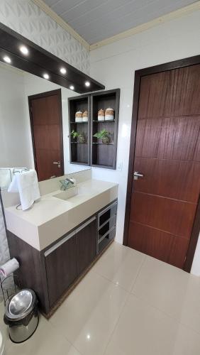 a bathroom with a sink and a large mirror at Próximo aSerra do Rio do Rastro in Lauro Müller