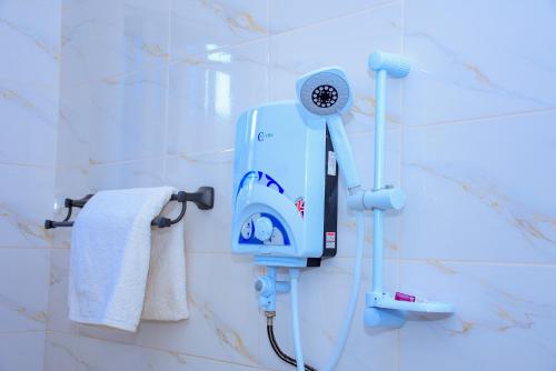 a blue hair dryer on the wall of a bathroom at JOSEPHINA LODGE Dodoma in Dodoma