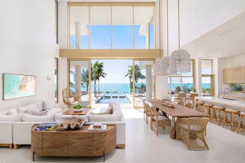 a living room with a table and a dining room at Kailoa Villa in Long Bay Hills