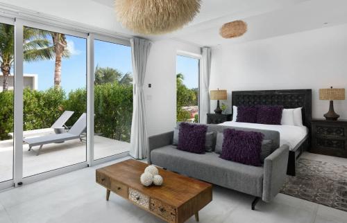 a bedroom with a bed and a couch and a table at Ocean Dream Studio Blue - Ocean View in Long Bay Hills