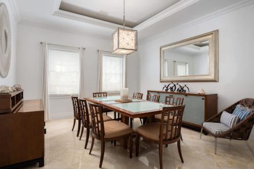 a dining room with a table and chairs and a mirror at Abundance and Prosperity Villa in Long Bay Hills
