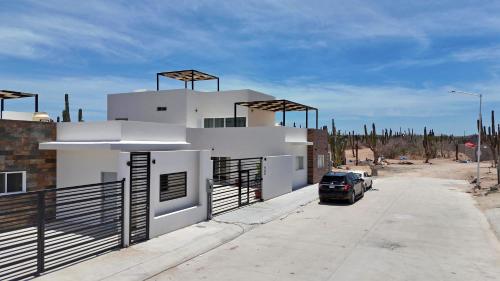 a car parked in front of a white house at 3BR House with Pool & Rooftop Terrace in El Centenario