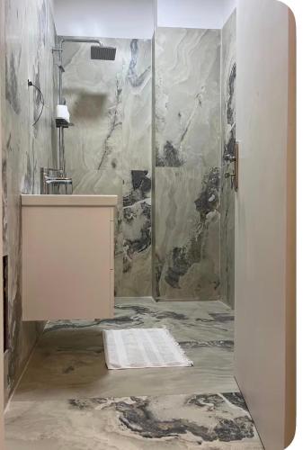 a bathroom with a shower and a sink at Ajans Apartament in Golem