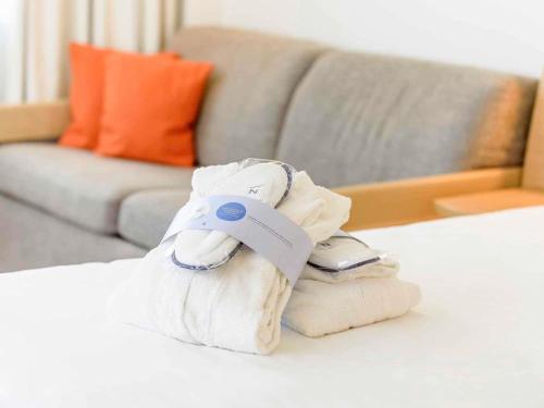 a phone sitting on top of a pile of towels at Novotel Aachen City in Aachen