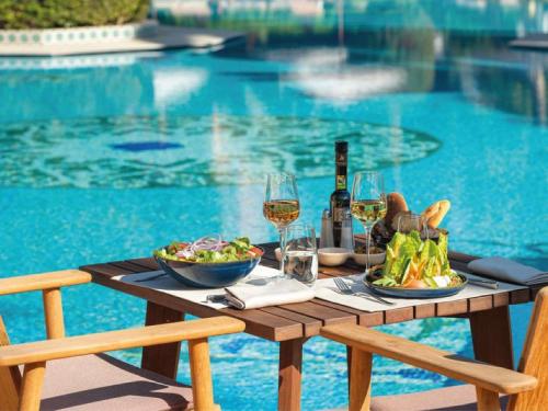 a picnic table with food and wine next to a pool at Sofitel Marrakech Palais Impérial & Spa in Marrakesh