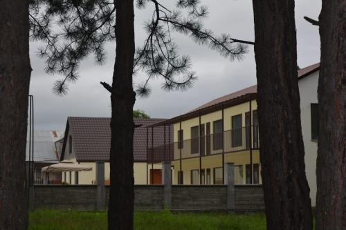 a yellow building with trees in the foreground at Amaras Boutique Hotel Lori in Stepʼanavan