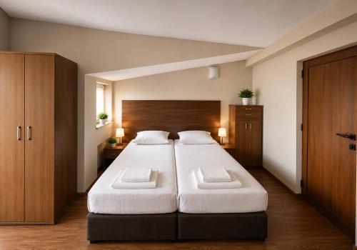 a bedroom with a large bed with two white pillows at Hotel Maria in Vratsa
