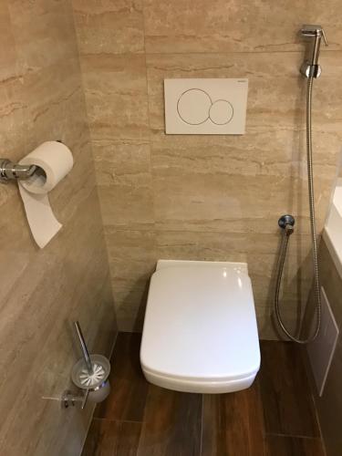 a bathroom with a toilet and a toilet paper dispenser at CenterCity Apartments in Prešov