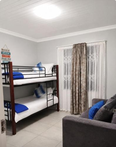 a living room with two bunk beds and a couch at Serenity Six Beach House in Hibberdene