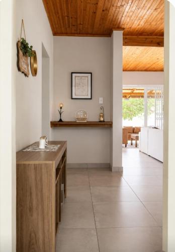 a kitchen with white walls and a wooden ceiling at Serenity Six Beach House in Hibberdene