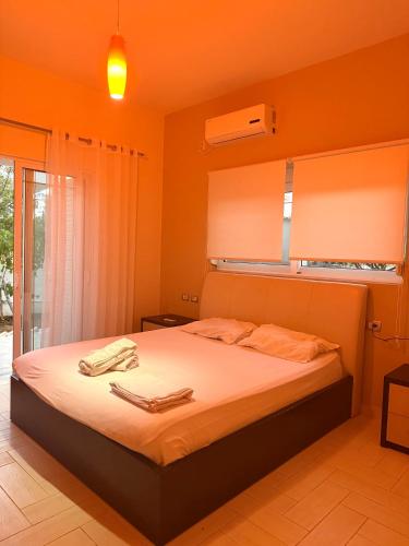 a bedroom with a bed with orange walls at Ksamil Harmony Studios in Ksamil