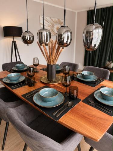 a dining room table with blue plates and silverware at Harmony Hideaways I 90qm I Bergblick I 3 Balkone I seenah in Prien am Chiemsee