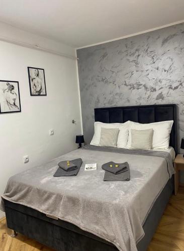 a bedroom with a bed with two towels on it at IN SILVER Apartman in Vršac