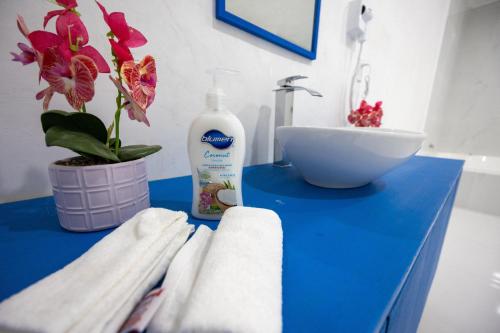 a bathroom with a blue counter with a sink and towels at Santorini Resort in Mérida