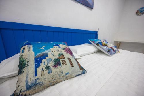 a bed with a pillow with a painting on it at Santorini Resort in Mérida
