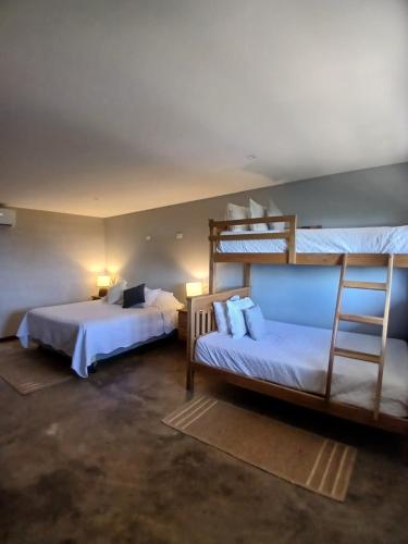 a bedroom with two bunk beds and a ladder at El Xalli Hotel in El Zonte