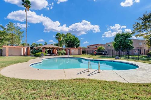 a swimming pool in a yard with a fence at Sunny & Bright Charm with Community Pool in Tucson