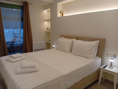 a bedroom with a large white bed with a window at Fyki sea view apartment in Vlikhón