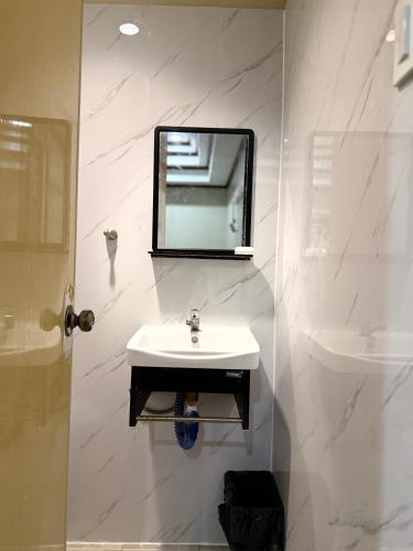 a bathroom with a sink and a mirror on the wall at Serenity Home - 4 bedroom home in Iloilo City