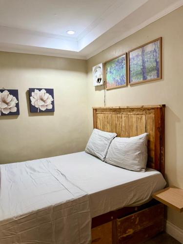 a bed in a room with two windows at Serenity Home - 4 bedroom home in Iloilo City