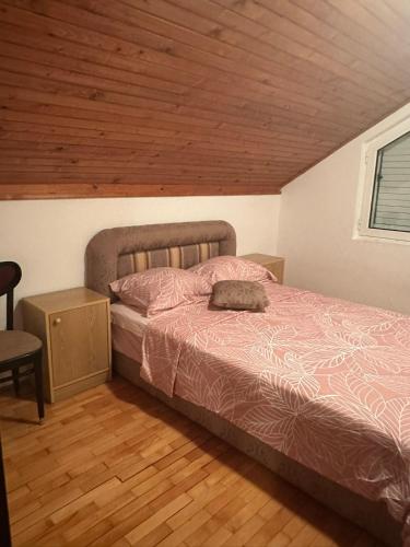 a bedroom with a bed and a wooden ceiling at Đenovici Apartmans in Đenovići