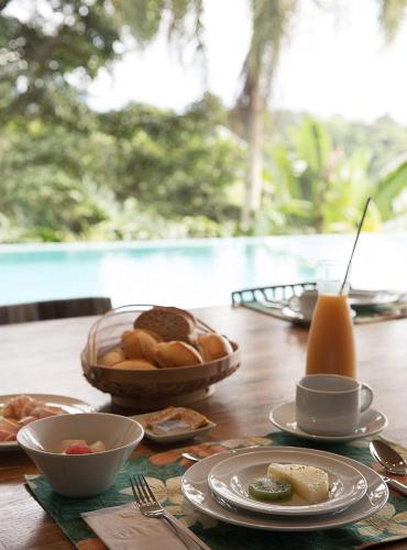 uma mesa com pratos de comida e uma tigela de pão em Casa Mar Paraty em Paraty