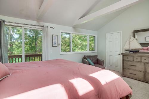 a bedroom with a large pink bed and windows at Riverside Extended Stay in Mashpee in Mashpee
