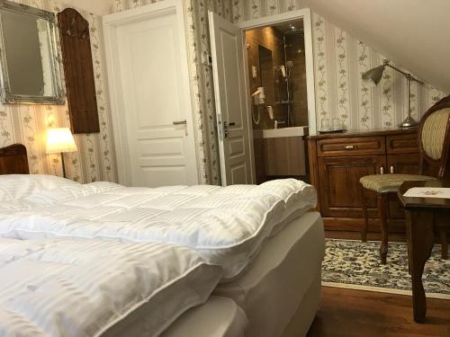 a bedroom with a white bed and a bathroom at CenterCity Apartments in Prešov