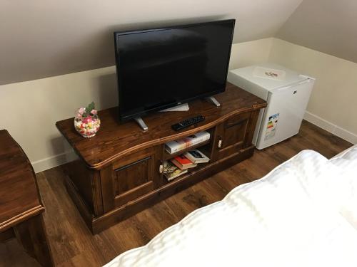 a television on a wooden stand in a bedroom at CenterCity Apartments in Prešov