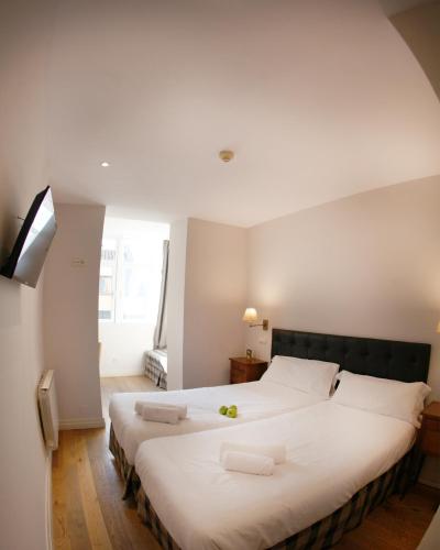 a bedroom with a large bed with two white pillows at Hotel Cuéntame La Puebla in Burgos