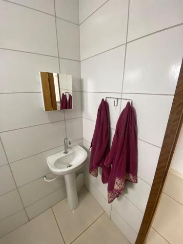 a bathroom with a sink and a toilet and towels at Aconchegante é silencioso in Rio Verde