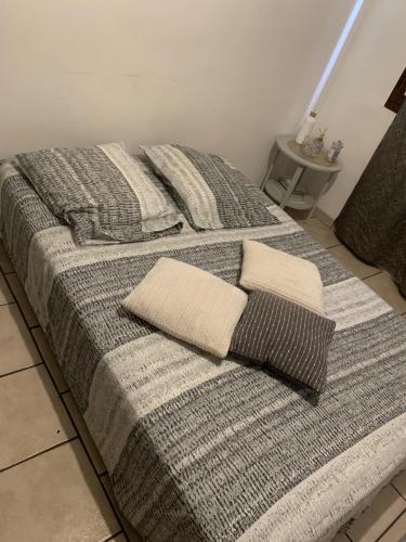 a bed with two pillows on top of it at Le Jocondien in Joué-lès-Tours