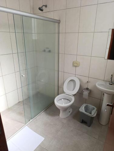 a bathroom with a shower and a toilet and a sink at Ubaense Suites in Ubá