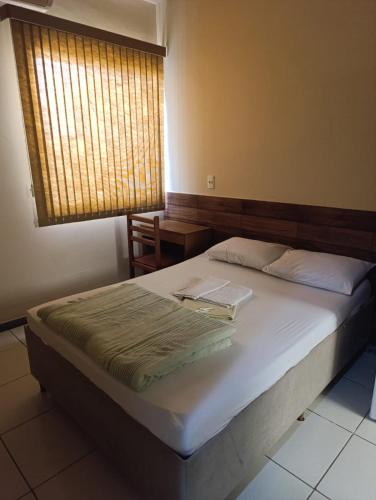 a bedroom with a bed with a laptop on it at Ubaense Suites in Ubá