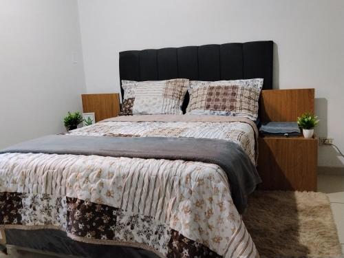 a bedroom with a large bed with a black headboard at Colman Apart Central 07 in Ciudad del Este