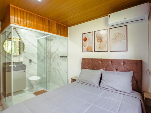 a bedroom with a bed and a glass shower at Hotel pousada BR 285 in Turvo
