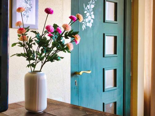 a vase with flowers sitting on a table in front of a door at Ferienwohnung Dreamy Daisy in Morbach