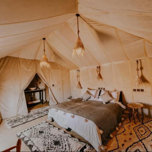 a bedroom with a bed in a tent at Sahara Nights Luxury Camp in Merzouga