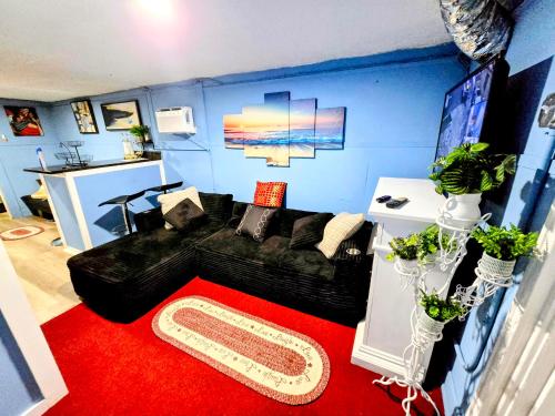 a living room with a black couch and a red carpet at 2 BEDROOM APARTMENT 20 min-Newark Airport 15 min- Stadium Downtown Newark- Branch Brook park inn in Newark