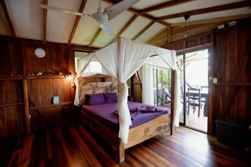 a bedroom with a bed with a canopy at Cabinas Jenny Cahuita in Cahuita