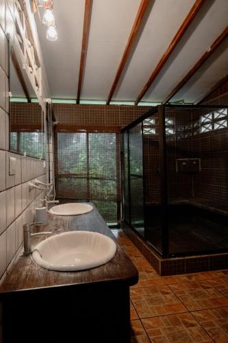 a large bathroom with two sinks and a shower at Cabinas Jenny Cahuita in Cahuita