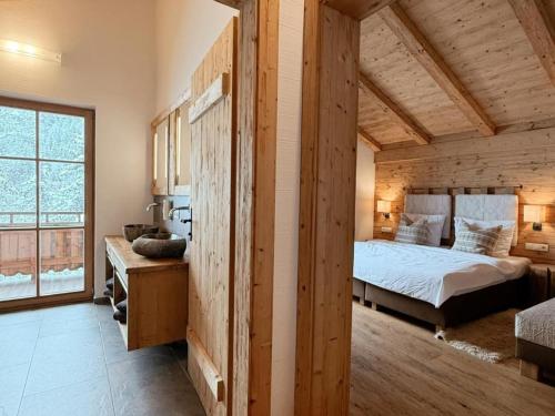a bedroom with a bed and a large window at Wildrose in Wagrain