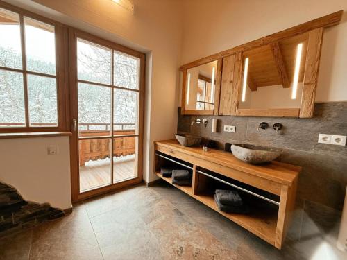 a bathroom with two sinks and a large window at Wildrose in Wagrain