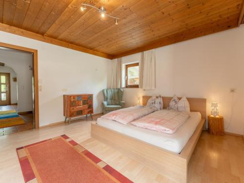 a bedroom with a large bed and a chair at Tauernpanorama in Krimml