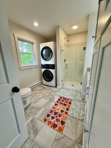 a bathroom with a shower and a toilet and a rug at The Happy Hive in Bridgton