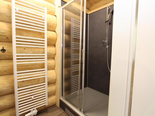 a shower in a bathroom with a wooden wall at Jenig 4A in Jenig